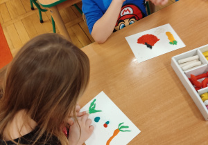 Dzieci tworzą warzywa z plasteliny.