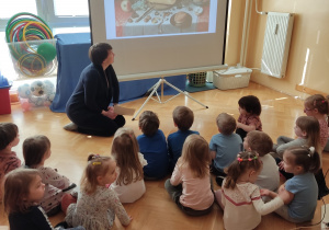Dzieci oglądają prezentację na ekranie.
