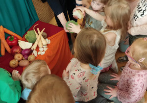Dzieci podziwiają wystawę z warzyw.