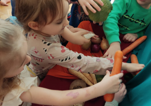 Dzieci dotykają warzyw.