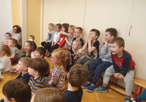 Dzieci na widowni słuchają czytanej bajki.