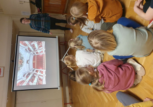 Na zdjęciu dzieci oglądają prezentację na temat opery