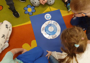 Dzieci układają puzzle "Cykl życia pingwina"