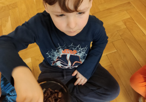 Chłopiec częstuje się kawałkiem czekolady.