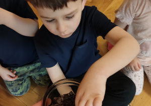 Chłopiec częstuje się kawałkiem czekolady.