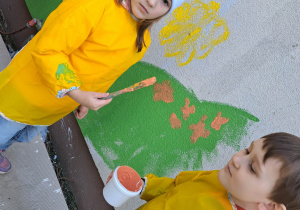 Dzieci malują budynek.