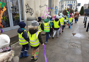Dzieci maszerują w okolicy przedszkola z gaikami i Marzanną