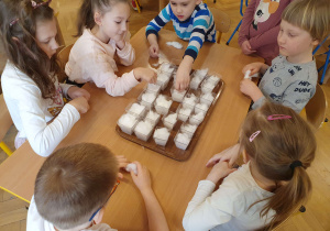 Na zdjęciu dzieci przygotowują doniczki i sieją rzeżuchę