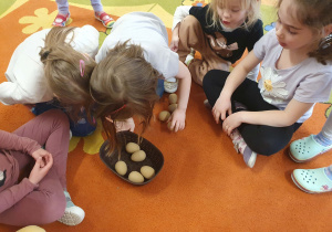 Na zdjęciu dzieci przeliczają jajka i sprawdzają która grupa wygrała