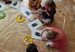 Dzieci rysują na podłodze.