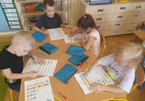 na zdjęciu dzieci kolorują kropki w kartach pracy