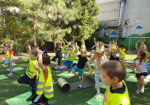 Na zdjęciu dzieci wykonują ćwiczenia z jogi