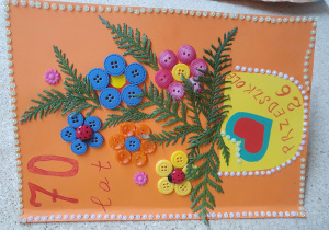 Zdjęcie przedstawia laurkę zrobioną z różnych materiałów z okazji urodzin przedszkola.