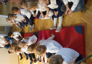 Zdjęcie przedstawia grupę małych dzieci oglądających występ starszaków.