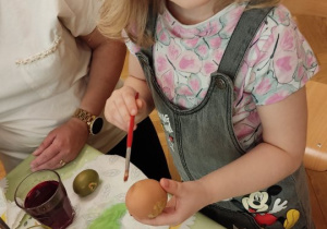 Dziewczynka tworzy jajko wielkanocne.