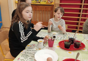 Dzieci dekorują jajka wielkanocne.