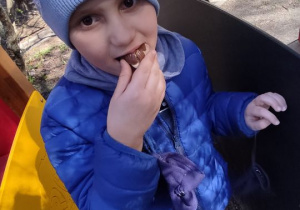 Chłopiec zjada jajko z czekolady.