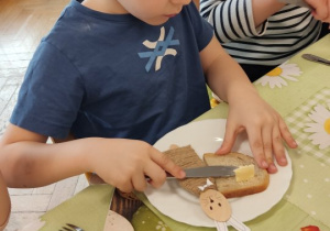 Chłopiec sam robi kanapkę.