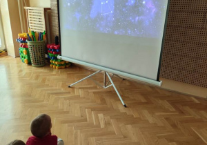 Przedszkolaki oglądają prezentację multimedialną.