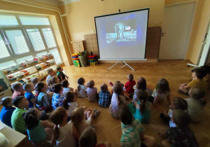 Przedszkolaki oglądają prezentację multimedialną.