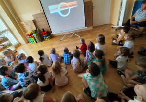 Przedszkolaki oglądają prezentację multimedialną.