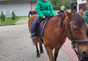 Chłopiec jedzie na koniku.