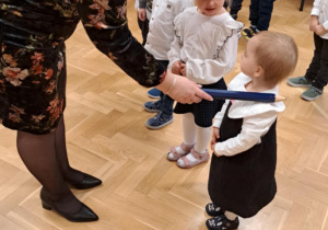 Dziewczynka pasowana na przedszkolaka ołówkiem przez Panią Dyrektor