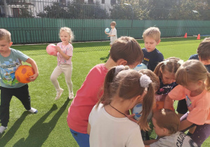 Dzieci ćwiczą z piłkami na przedszkolnym tarasie