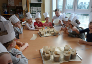 Dzieci słuchają Pana kucharza o tym jak prawidłowo wykonać swoją pracę