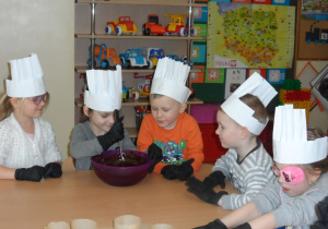 Dzieci mieszają czekoladę do ciasteczek