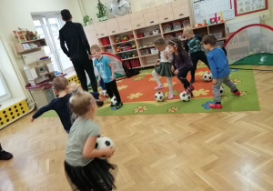Dzieci wykonują ćwiczenia pokazane przez trenerów