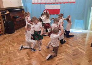 Grupa starsza wykonuje taniec ludowy.