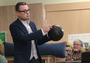 Pan prowadzący prezentuje instrument muzyczny.