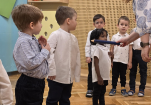 Pasowanie - dzieci stoją w szeregu, pasowanie dziewczynki