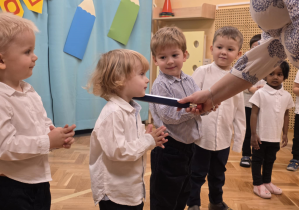 Pasowanie - dzieci stoją w szeregu, pasowanie chłopca