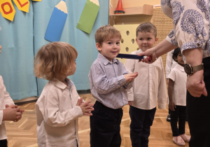 Pasowanie - dzieci stoją w szeregu, pasowanie chłopca