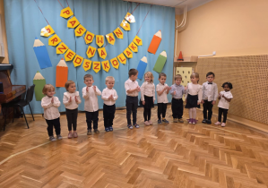 Pasowanie - dzieci stoją w szeregu, śpiewają piosenkę