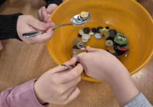 Zabawy dzieci z guzikami i wodą.