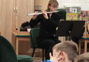 Artystka gra na flecie.