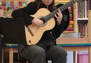 Artystka gra na gitarze, prezentuje instrument.