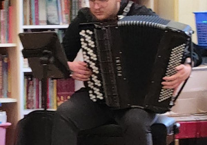 Artysta gra i prezentuje na instrumencie - akordeon.