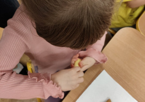 Dziewczynka dekoruje pierniczka.