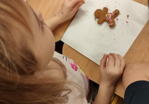 Dziewczynka dekoruje pierniczka.