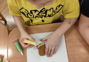 Chłopiec dekoruje pierniki.