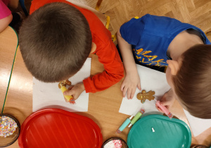 Chłopcy dekorują pierniki.