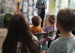 Prowadzący koncert opowiada o operze.