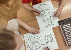 Dzieci wykonują ćwiczenie grafomotoryczne.