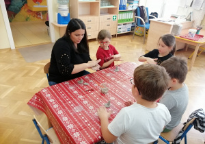 Dzieci przy stoliku lepią z gliny.