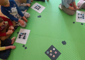 Gra w "Misiowe Bingo". Dzieci wspólnie siedzą na dywanie