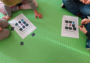 Gra w "Misiowe Bingo". Dzieci wspólnie siedzą na dywanie